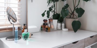 Zrcátko a kosmetika na stolku u okna