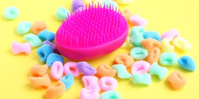 Barevné gumičky a růžový kartáč na vlasy