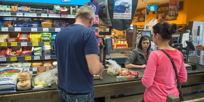 Lidé jsou u pokladny v obchodě