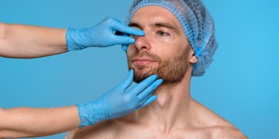 Lékař si prohlíží nos pacienta před potenciálním estetickým zákrokem