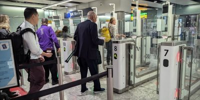 Cestující procházejí bezpečnostní kontrolou na letišti