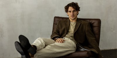 Muž v saku sedí na křesle