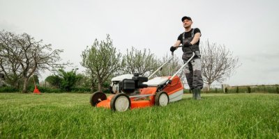 Muž seká trávník