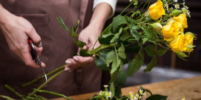 Květinářka stříhá konce stonků