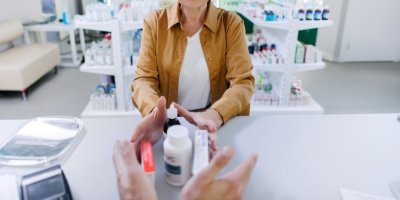 Žena vrací léky do lékárny