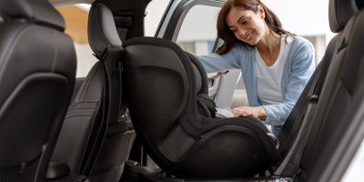 Žena dává autosedačku do auta