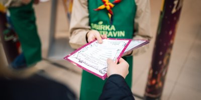 Dobrovolník předává letáček