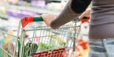 Žena s nákupním vozíkem v supermarketu