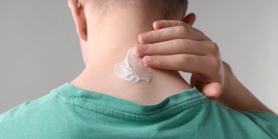 Muž si nanáší krém na krk