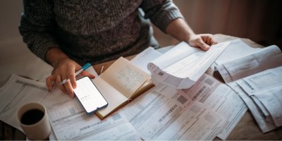 Detail mužských rukou s kalkulačkou a účty za veřejné služby