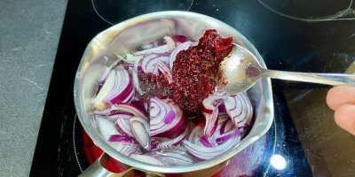 Přidávání brusinkové marmelády do hrnce s cibulí