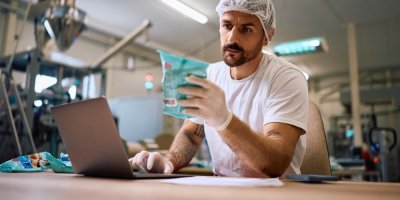 Pracovník v továrně analyzuje potravinový obal 