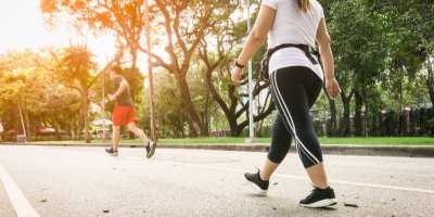 Žena s nadváhou ve sportovním oblečení se prochází po parku