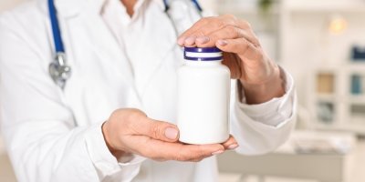 Lékař drží v rukou balení léků