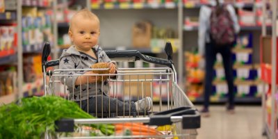 Dítě v nákupním vozíku v supermarketu