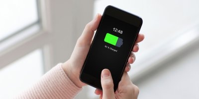 Žena drží v rukou mobilní telefon nabitý na 82 procent