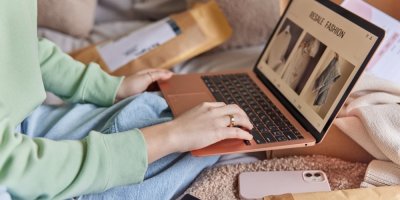 Žena se dívá na e-shop s oblečením z druhé ruky