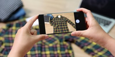 Žena přes telefon fotí kostkovanou košili