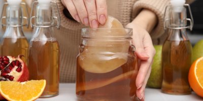 Žena připravující fermentovaný nápoj z kombuchy