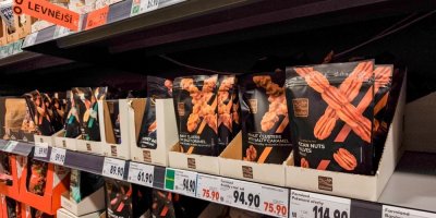 Balené produkty s cenovkami v regálu supermarketu