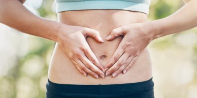 Štíhlá žena s dlaněmi položenými na břiše