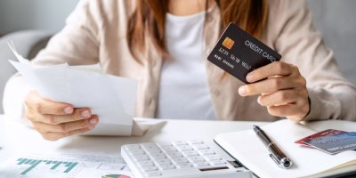 Žena s účtenkami a kreditní kartou počítá finance
