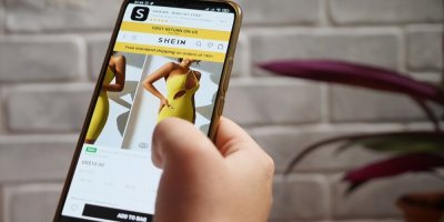 Člověk si prohlíží šaty na e-shopu Shein na mobilním telefonu