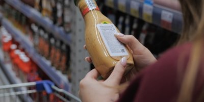 Zákaznice při nákupu v supermarketu čte obsah složení na produktu