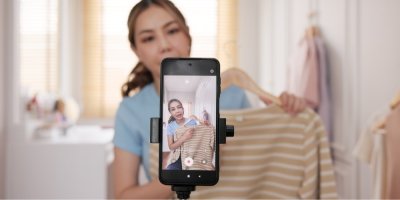 Mladá Asiatka nabízí oblečení přes mobilní videozáznam