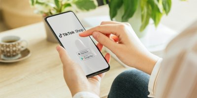 Žena drží v rukou mobilní telefon s aplikací TikTok Shop