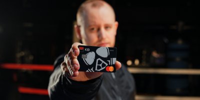 Muž drží platební kartu v rukou