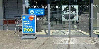 Vstup do prodejny Lidlu s cedulí o změně otvírací doby