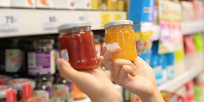 Ruce držící dvě sklenice džemu v supermarketu