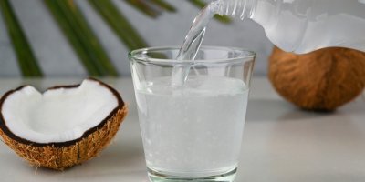 Kokosový ořech a kokosová voda ve sklenici