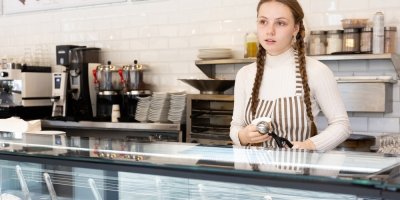 Mladá dívka na brigádě u pultu se zmrzlinou