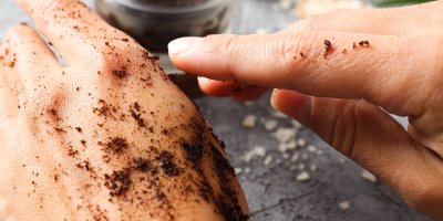 Domácí kávový peeling nanesený na pokožce ruky