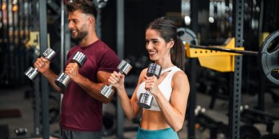 Muž a žena posilují ve fitness centru