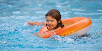 Dívka se koupe v kruhu v bazénu