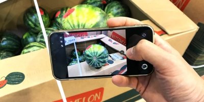 Muž fotí přes telefon vodní meloun v supermarketu