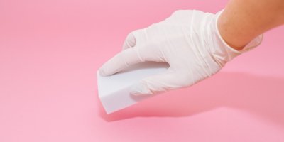 Ruka v úklidové rukavici drží nano houbičku