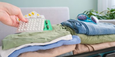 Žena dává léky do cestovního kufru
