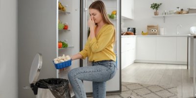 Žena vyhazuje žampiony z lednice do koše