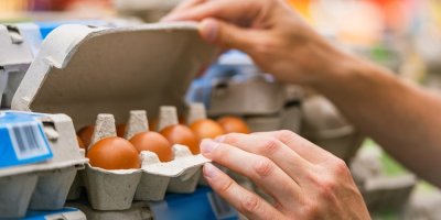 Zákaznice kontroluje plato vajec v supermarketu