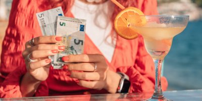 Žena drží eurové bankovky během dovolené v zahraničí