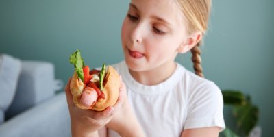 Malá dívka konzumuje hot dog