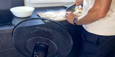 Muž krájí cibuli vedle ventilátoru