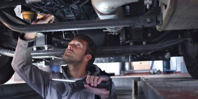 Automechanik kontroluje podvozek auta