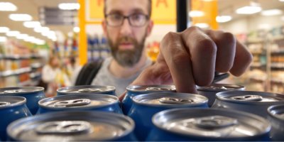 Zákazník nakupuje pivo v plechovce v supermarketu
