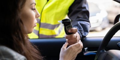 Řidička podstupující dechovou zkoušku při silniční kontrole