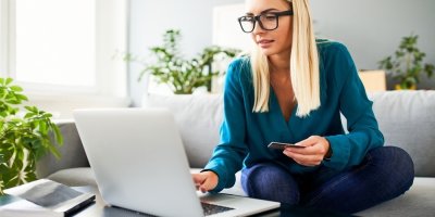 Žena platí platební kartou při nákupu na internetu a kontroluje objednávku na notebooku